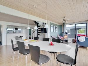 a dining room and living room with a white table and chairs at Holiday Home Dunja - 200m to the inlet in The Liim Fiord by Interhome in Vinderup