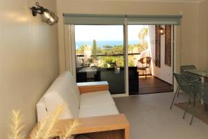 een woonkamer met een witte bank en een balkon bij Ocean View Hydrangea - 2 Bedroom Apartment at São Rafael Beach, Albufeira in Albufeira