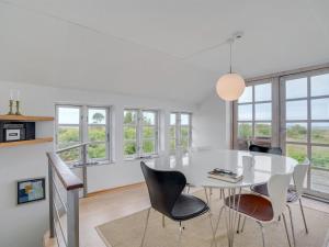 a white dining room with a white table and chairs at Holiday Home Gren - 90m to the inlet in The Liim Fiord by Interhome in Roslev