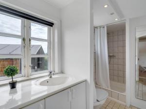 a bathroom with a sink and a toilet and a window at Holiday Home Gren - 90m to the inlet in The Liim Fiord by Interhome in Roslev