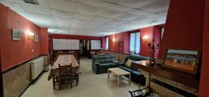 a room with red walls and a waiting room with couches at Río España - Casa amplia con patio y barbacoa en Villaviciosa in Villaviciosa