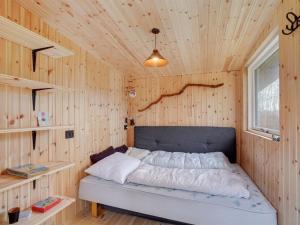 1 dormitorio con 1 cama en una pared de madera en Holiday Home Fridlef - 200m to the inlet in The Liim Fiord by Interhome en Fur