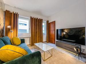 - un salon avec un canapé bleu et une grande télévision dans l'établissement Quiet & Comfy apartment on Av du Casino, à Montreux