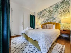 a bedroom with a large bed with a tropical wallpaper at Quiet & Comfy apartment on Av du Casino in Montreux
