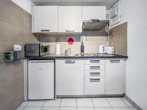 a kitchen with white cabinets and a white refrigerator at Quiet & Comfy apartment on Av du Casino in Montreux