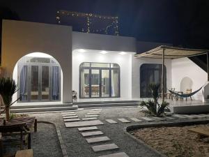 a white house with a patio at night at My Hoa Oceanfront Home in Ấp Mỹ Hải