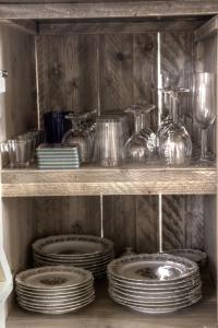 une étagère en bois avec des assiettes et des verres dans l'établissement Domaine des Z'Ailés, à Saint-Florent-des-Bois