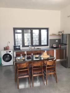 - une cuisine avec une table, des chaises et une cuisinière dans l'établissement My Hoa Oceanfront Home, à Ấp Mỹ Hải