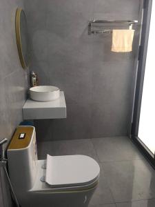 ein Badezimmer mit einem weißen WC und einem Waschbecken in der Unterkunft My Hoa Oceanfront Home in Ấp Mỹ Hải