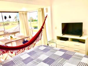 a hammock in a bedroom with a tv and a bed at Condomínio Gavoa Resort - 2 quartos - BL D apt 209 in Igarassu