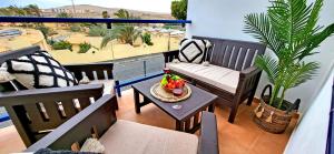a balcony with chairs and a table with a bowl of fruit at Casa Fiona in Costa Calma