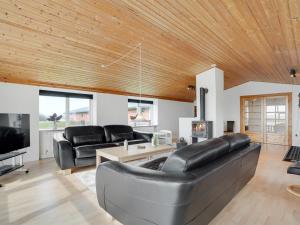 una sala de estar con muebles de cuero y techo de madera. en Holiday Home Imilie - 250m to the inlet in The Liim Fiord by Interhome, en Redsted