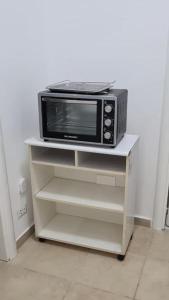 a microwave sitting on a white stand in a kitchen at Roomors Of Naples - Sea View Apartment in Naples