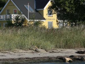 a yellow house next to a field of tall grass at Holiday Home Rina - 30m to the inlet in The Liim Fiord by Interhome in Fur