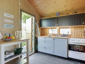 cocina con electrodomésticos blancos y techo de madera en Holiday Home Ani - 100m from the sea in SE Jutland by Interhome en Odder