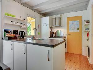 a kitchen with white cabinets and a black counter top at Holiday Home Ethil - 300m to the inlet in The Liim Fiord by Interhome in Lihme