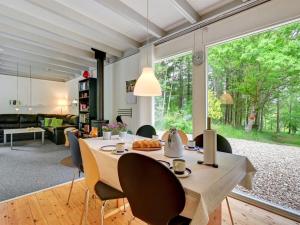 a dining room with a table and chairs and a large window at Holiday Home Ethil - 300m to the inlet in The Liim Fiord by Interhome in Lihme