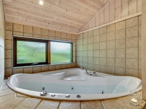 een groot bad in een kamer met een raam bij Holiday Home Gustine - 300m from the sea in Djursland and Mols by Interhome in Egå