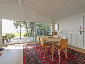 cocina y comedor con mesa de madera y sillas en Holiday Home Elissa - 50m to the inlet in The Liim Fiord by Interhome, en Roslev