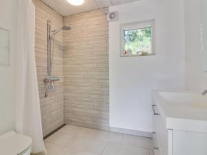 y baño con ducha y lavamanos. en Holiday Home Elissa - 50m to the inlet in The Liim Fiord by Interhome, en Roslev