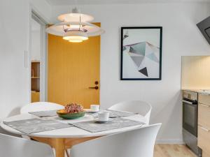 een eetkamer met een tafel en witte stoelen bij Holiday Home Thomsen - 200m to the inlet in The Liim Fiord by Interhome 