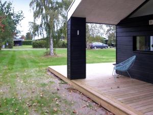 a house with a wooden deck with a bench on it at Holiday Home Yukon - 150m from the sea in SE Jutland by Interhome in Odder