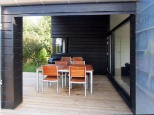 a wooden table and chairs on a patio at Holiday Home Yukon - 150m from the sea in SE Jutland by Interhome in Odder