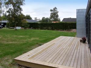 a wooden deck in the yard of a house at Holiday Home Yukon - 150m from the sea in SE Jutland by Interhome in Odder
