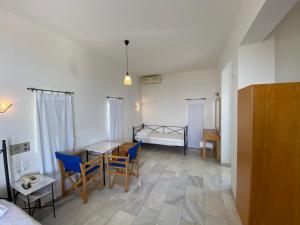 a room with a bed and a table and chairs at Hotel Plakures in Falasarna