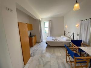 a room with a bed and a table and chairs at Hotel Plakures in Falasarna