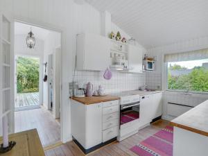 a white kitchen with white cabinets and a window at Holiday Home Suoma - 400m to the inlet in The Liim Fiord by Interhome in Roslev