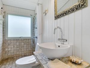 y baño con lavabo, aseo y espejo. en Holiday Home Suoma - 400m to the inlet in The Liim Fiord by Interhome, en Roslev