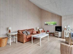 een woonkamer met een bank en een tafel bij Holiday Home Regni - 300m to the inlet in The Liim Fiord by Interhome in Nykøbing Mors