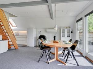 cocina y comedor con mesa de madera y sillas en Holiday Home Femija - 500m to the inlet in The Liim Fiord by Interhome en Roslev