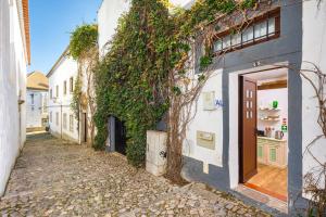 an alley with ivy on the side of a building at Galeria Guesthouse in Tavira