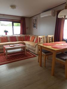 ein Wohnzimmer mit einem Sofa, einem Tisch und Stühlen in der Unterkunft Beach Resort Kamperland - 771 in Kamperland