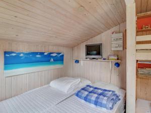 een kleine kamer met een bed en een televisie bij Holiday Home Cristina - from the sea in SE Jutland by Interhome in Odder