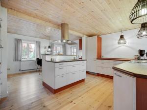 eine Küche mit weißen Schränken und einer Holzdecke in der Unterkunft Holiday Home Malinda - 500m from the sea in SE Jutland by Interhome in Odder