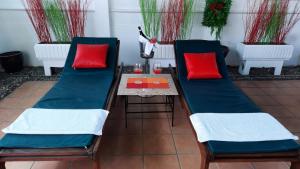 a patio with two chairs and a table with red pillows at Swiss Food Restaurant and room for rent in Pattaya South