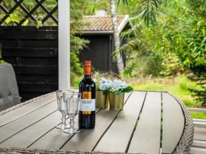 eine Flasche Wein auf einem Tisch mit Brille in der Unterkunft Holiday Home Fiallar - 7-5km from the sea in Djursland and Mols by Interhome in Rønde