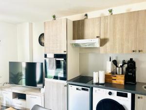 a kitchen with white cabinets and a microwave at Les Jardins des Senteurs - Appartement privé avec piscine et parking in Grasse
