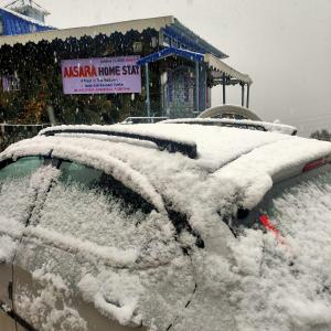 a snow covered car parked in front of a store at Aasara HomeStay Soli Kausani in Kausani