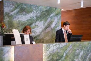 a man and woman sitting at a counter with their computers at Hotel Kraft in Florence