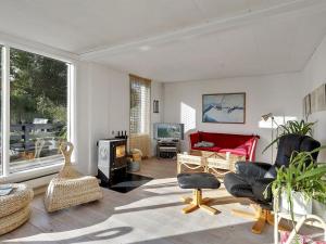 MallingにあるHoliday Home Melina - 100m from the sea in SE Jutland by Interhomeのリビングルーム(赤いソファ、椅子付)