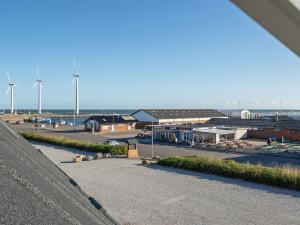 uma vista de um parque de estacionamento com turbinas eólicas ao fundo em Apartment Line - 10m from the sea in Djursland and Mols by Interhome em Glesborg