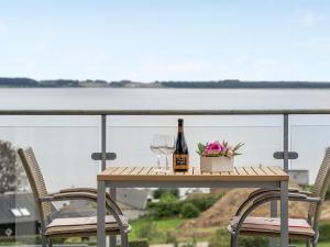 einen Tisch mit einer Flasche Wein und zwei Gläsern in der Unterkunft Holiday Home Eilen - 250m from the sea in Djursland and Mols by Interhome in Ebeltoft