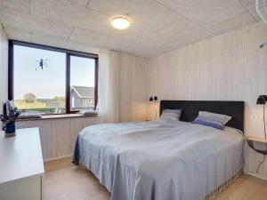 1 dormitorio con 1 cama grande y ventana grande en Holiday Home Fritze - 400m from the sea in Djursland and Mols by Interhome, en Glesborg