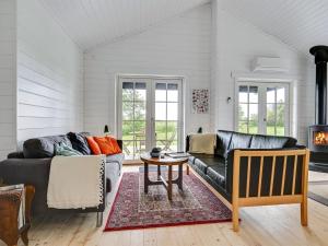 ein Wohnzimmer mit 2 Sofas und einem Tisch in der Unterkunft Holiday Home Siebelt - 200m from the sea in Djursland and Mols by Interhome in Knebel