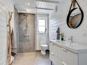 ein Bad mit einer Dusche, einem Waschbecken und einem WC in der Unterkunft Holiday Home Siebelt - 200m from the sea in Djursland and Mols by Interhome in Knebel