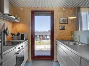 uma cozinha com uma porta que leva a um pátio em Holiday Home Eila - 400m from the sea in Djursland and Mols by Interhome em Glesborg